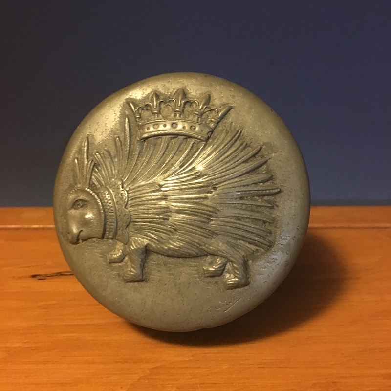 photo of a pewter container with a relief of a hedghog with a crown