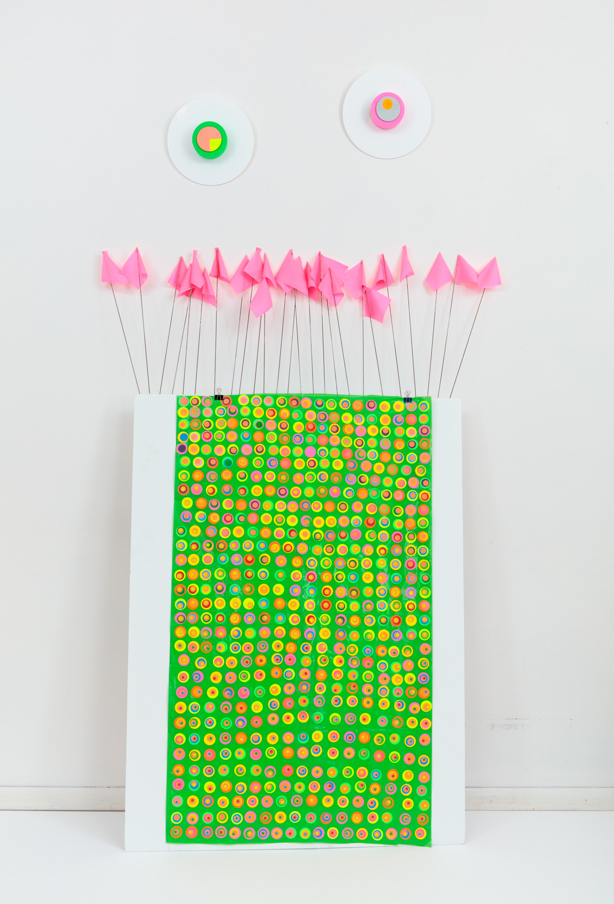 Green plastic sheet covered with brighly colored dots